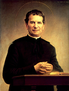 Statue of Don Bosco with youth beside an image of Mary Help of Christians